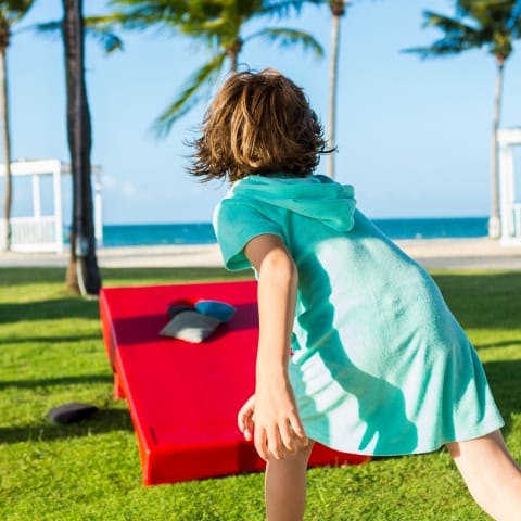 kid playing cornhole outdoors kid playing cornhole outdoors